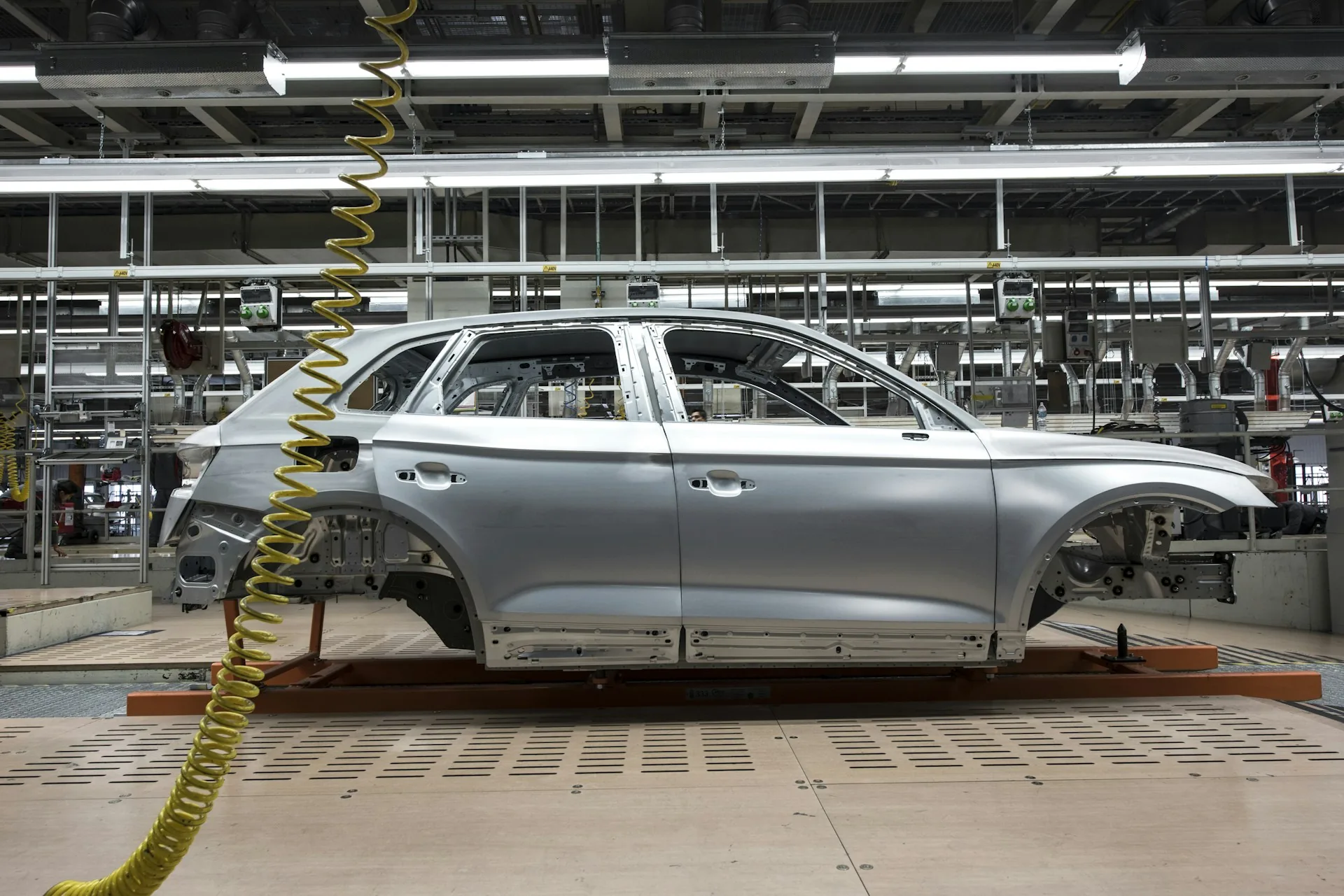 Carrocería de un vehículo sin pintar sobre la línea de montaje de una fábrica de automóviles