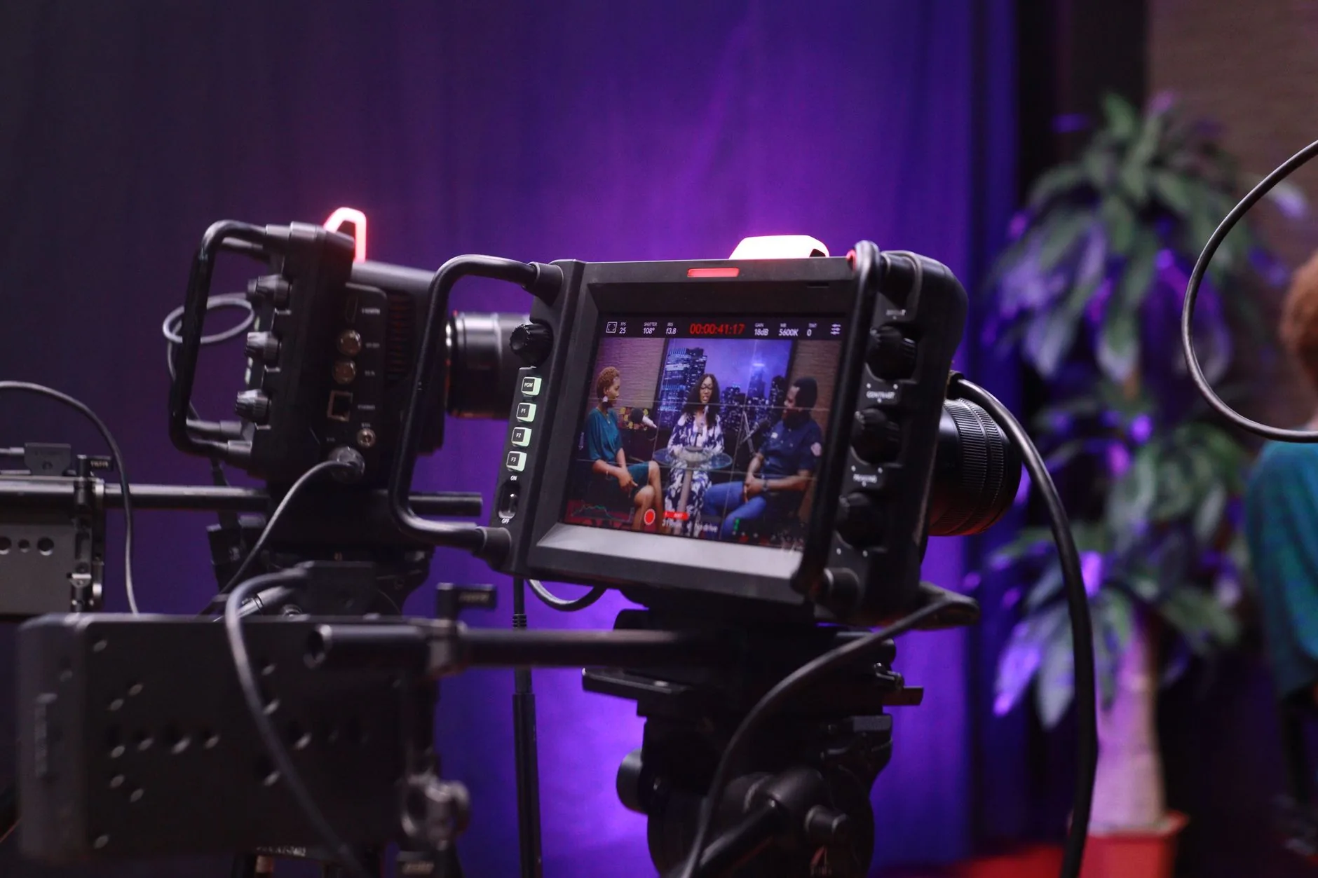 Cámara de vídeo profesional en set de entrevista corporativa con iluminación lateral