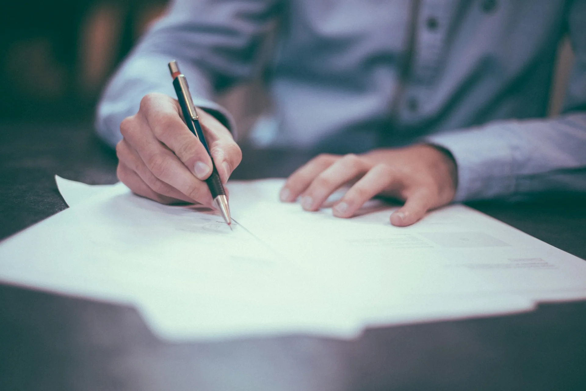 Persona firmando un documento de cesión de derechos de imagen en una oficina