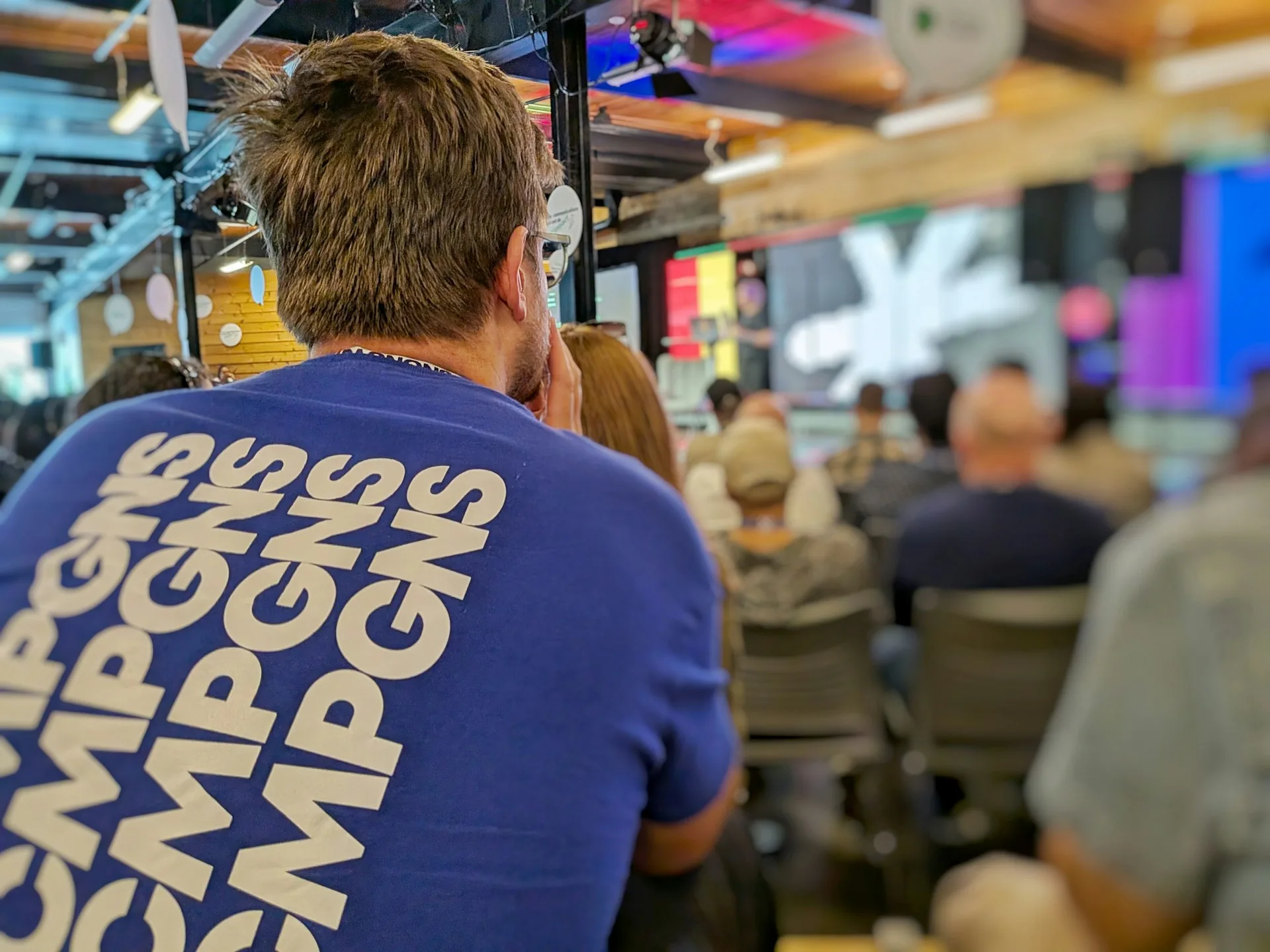 Attendee in a blue shirt at an indoor corporate event