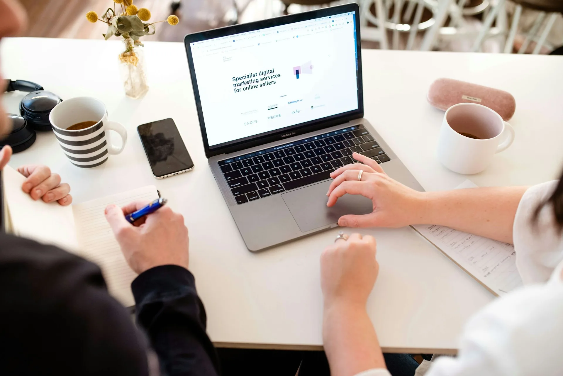 Two people reviewing a project together on a laptop screen