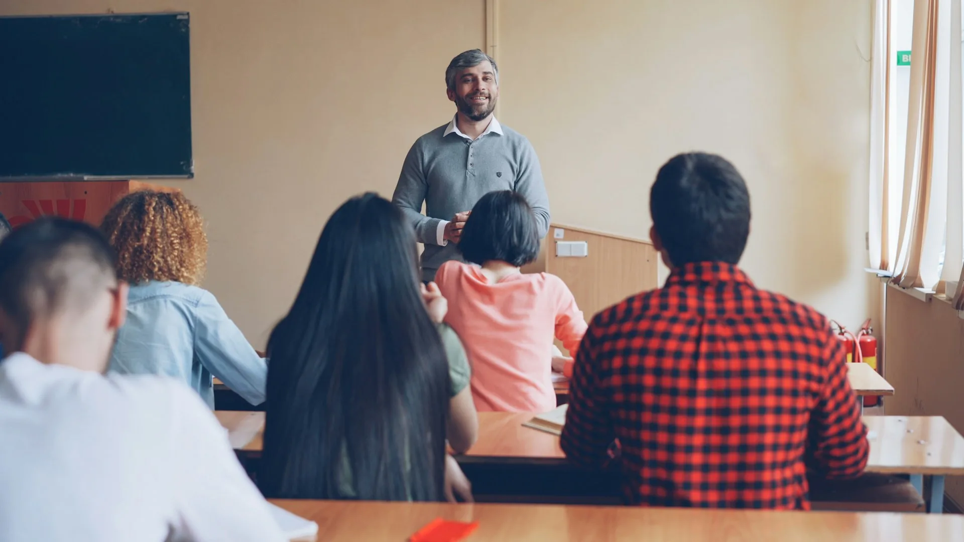 Teacher explaining to a group of students seated in a classroom