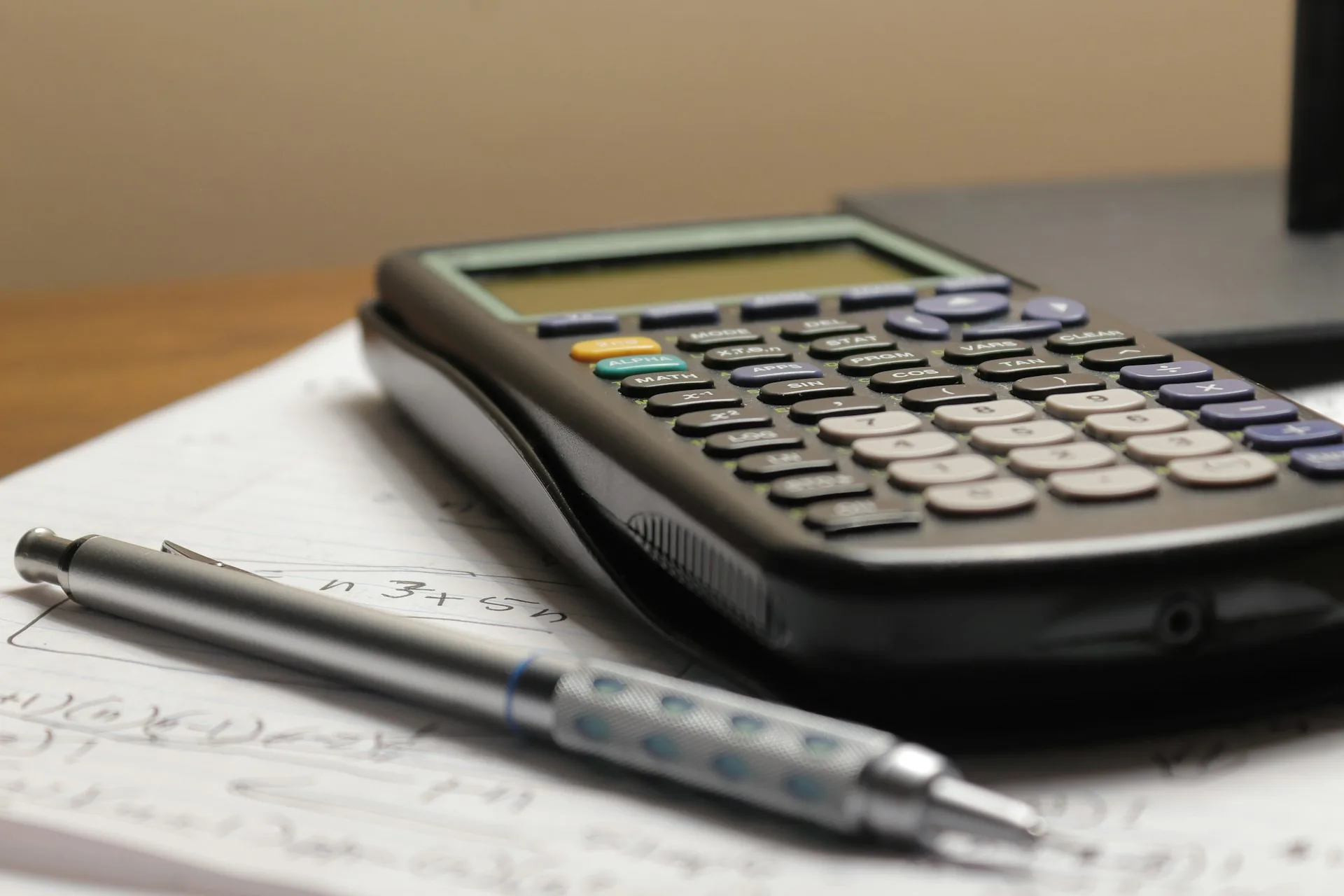 Calculadora y bolígrafo sobre un documento en una mesa de trabajo