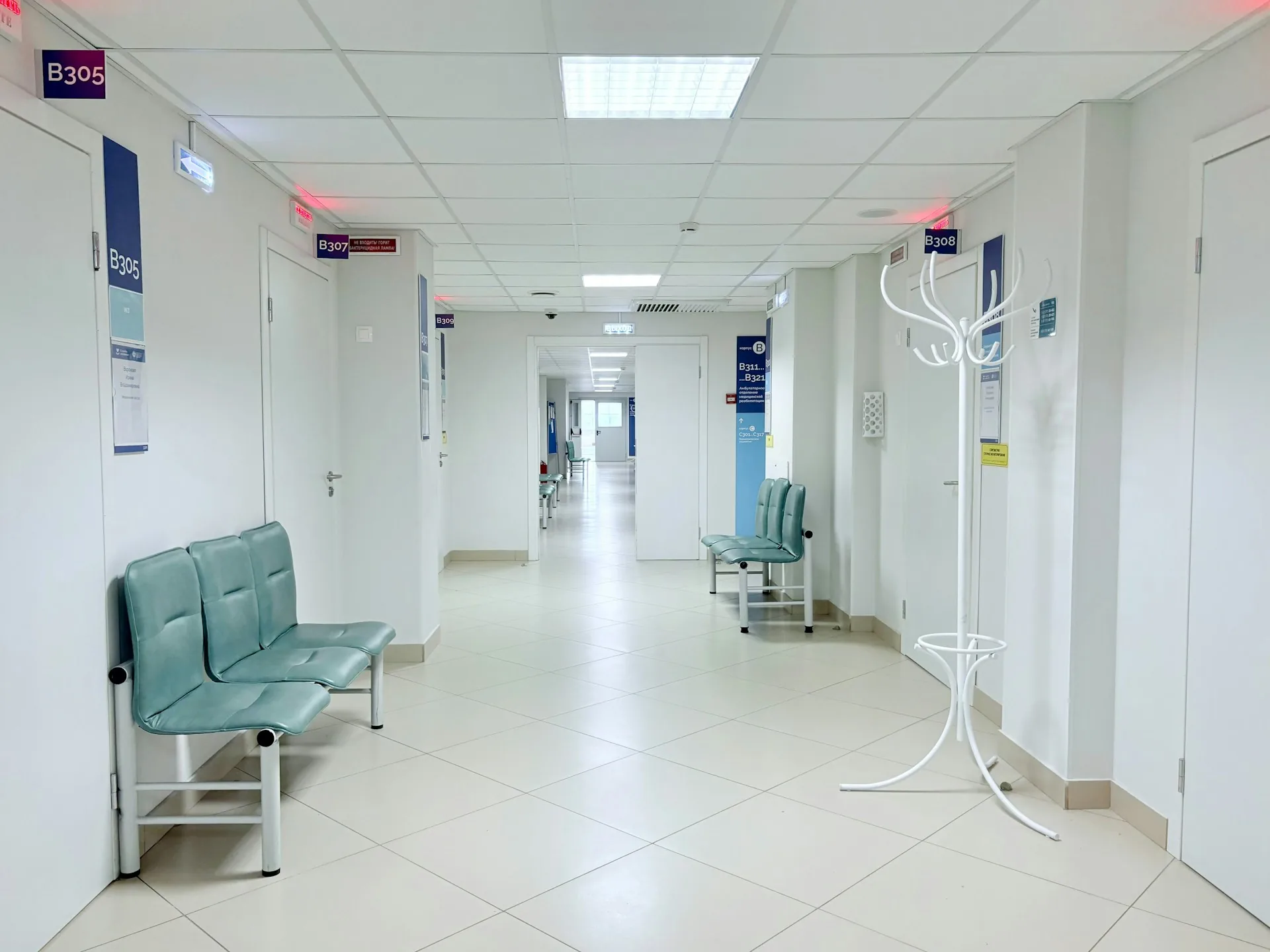 Pasillo de un centro sanitario con bancos y puertas de consulta