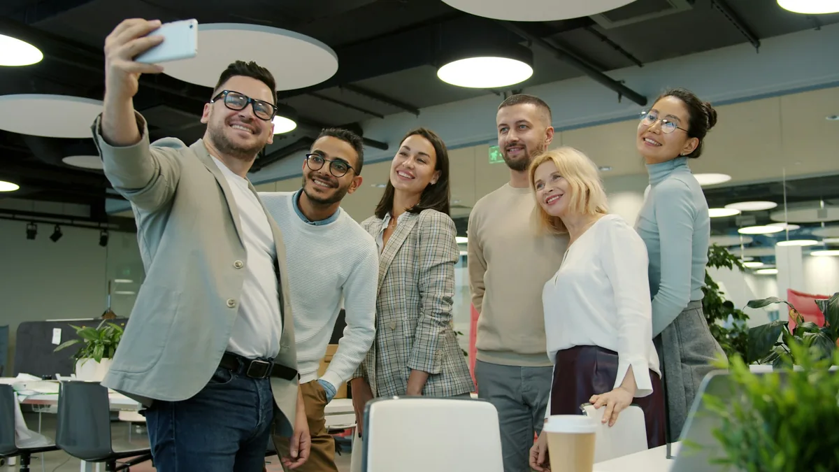Grupo de compañeros sonriendo para una foto en una oficina moderna
