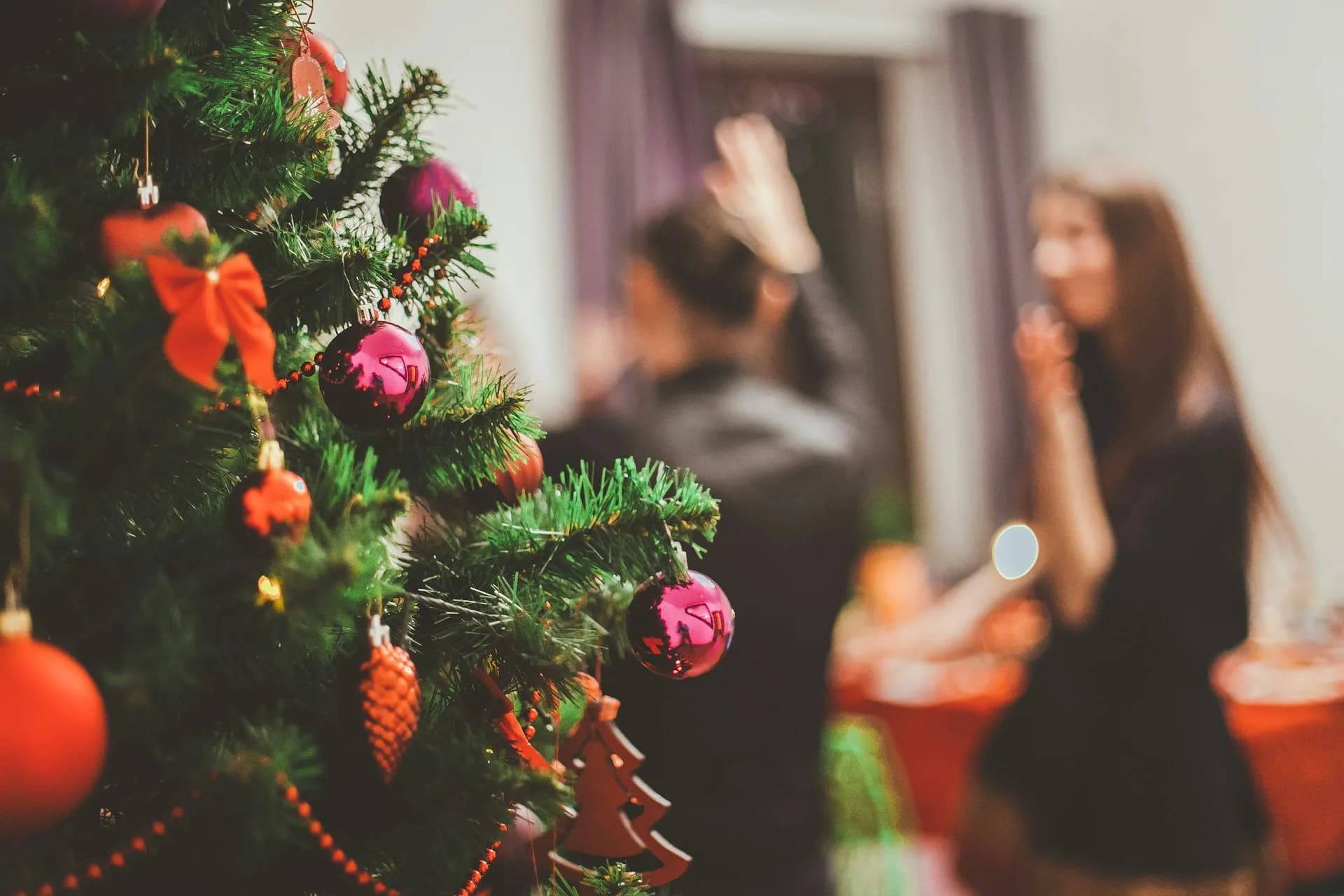Árbol de Navidad con luces desenfocadas al fondo, ambiente de felicitación navideña